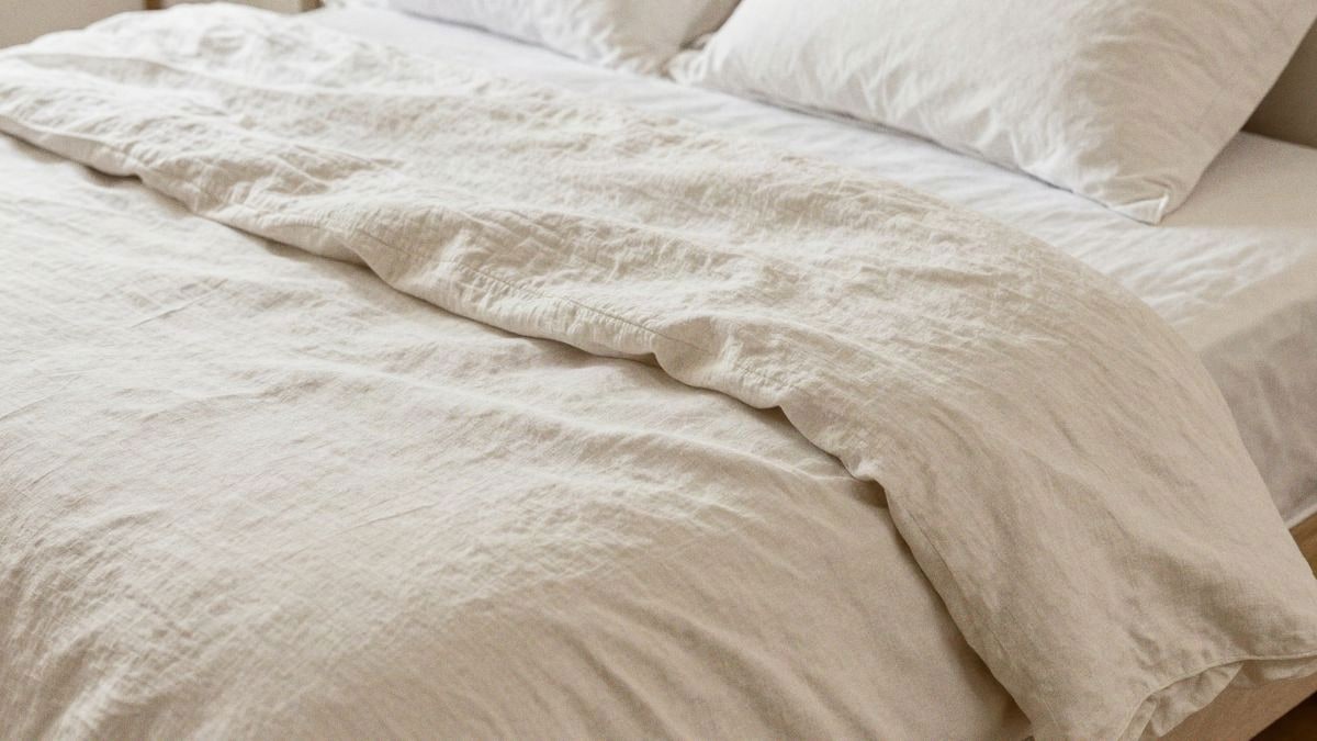 Imagen ilustrativa: detalle de sábanas de lino blanco crema dobladas mostrando su textura natural
